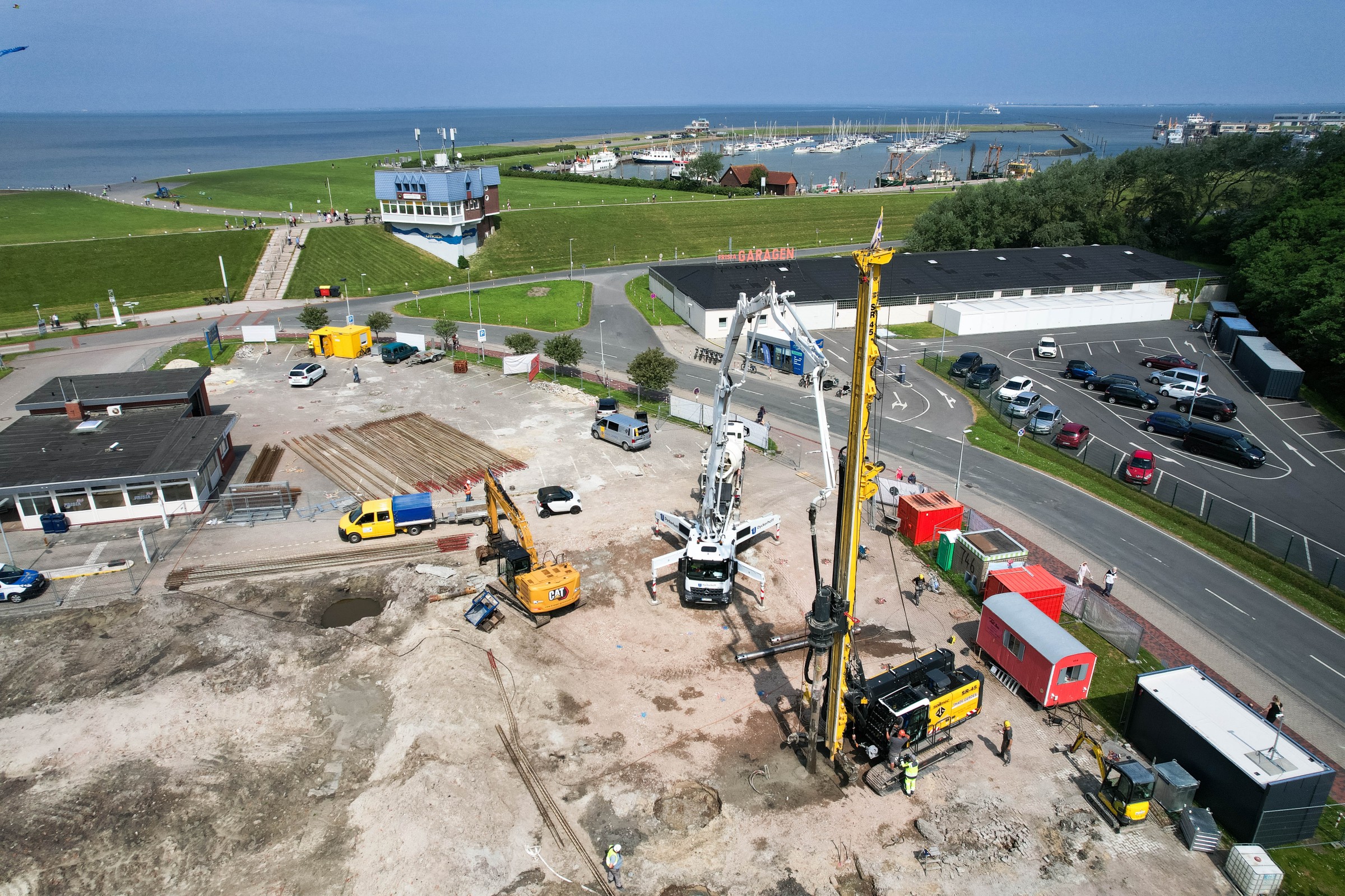Pfahlgründung Baustelle an der Nordseeküste mit einem großen Bohrgerät und mehreren Baustellenfahrzeugen von Thade Gerdes