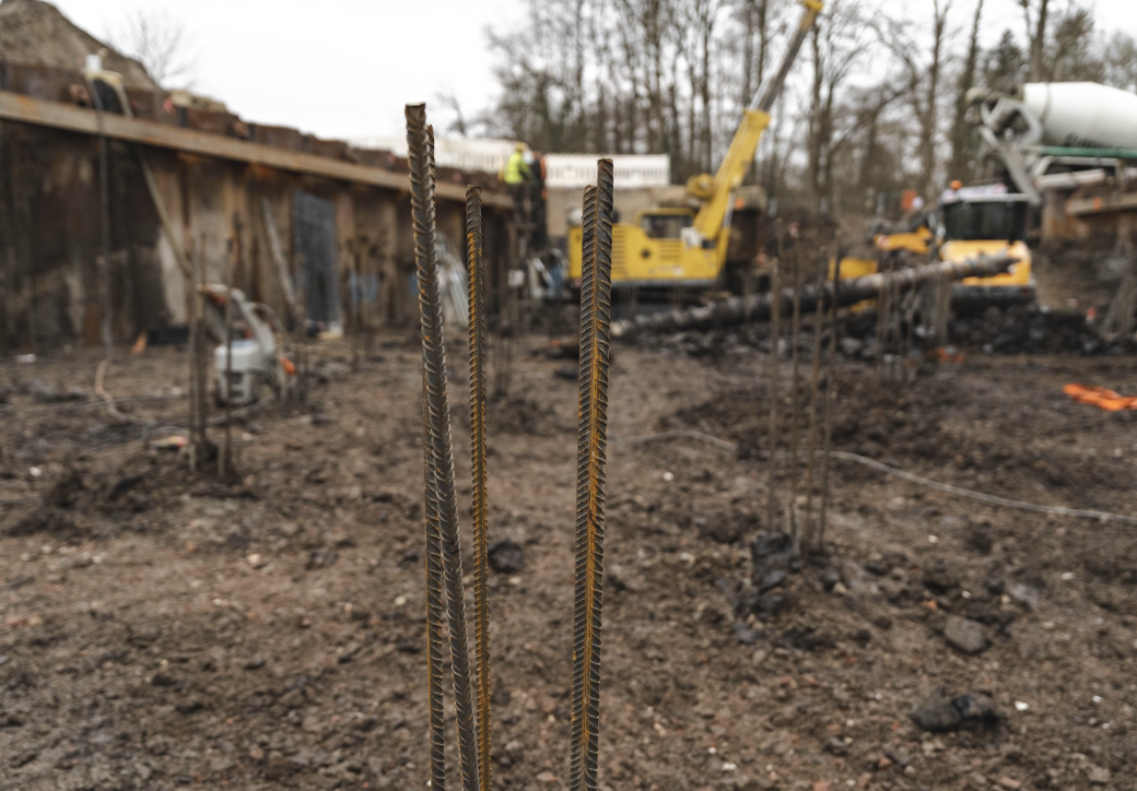 Fertige Bohrpfähle bzw. mehrere senkrecht aus dem Boden ragende Stahlstäbe eines Bohrpfahls