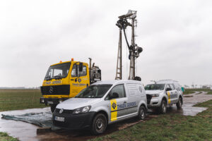 Bohrgerät und Einsatzfahrzeuge bei der Baugrunderkundung auf einer Baustelle