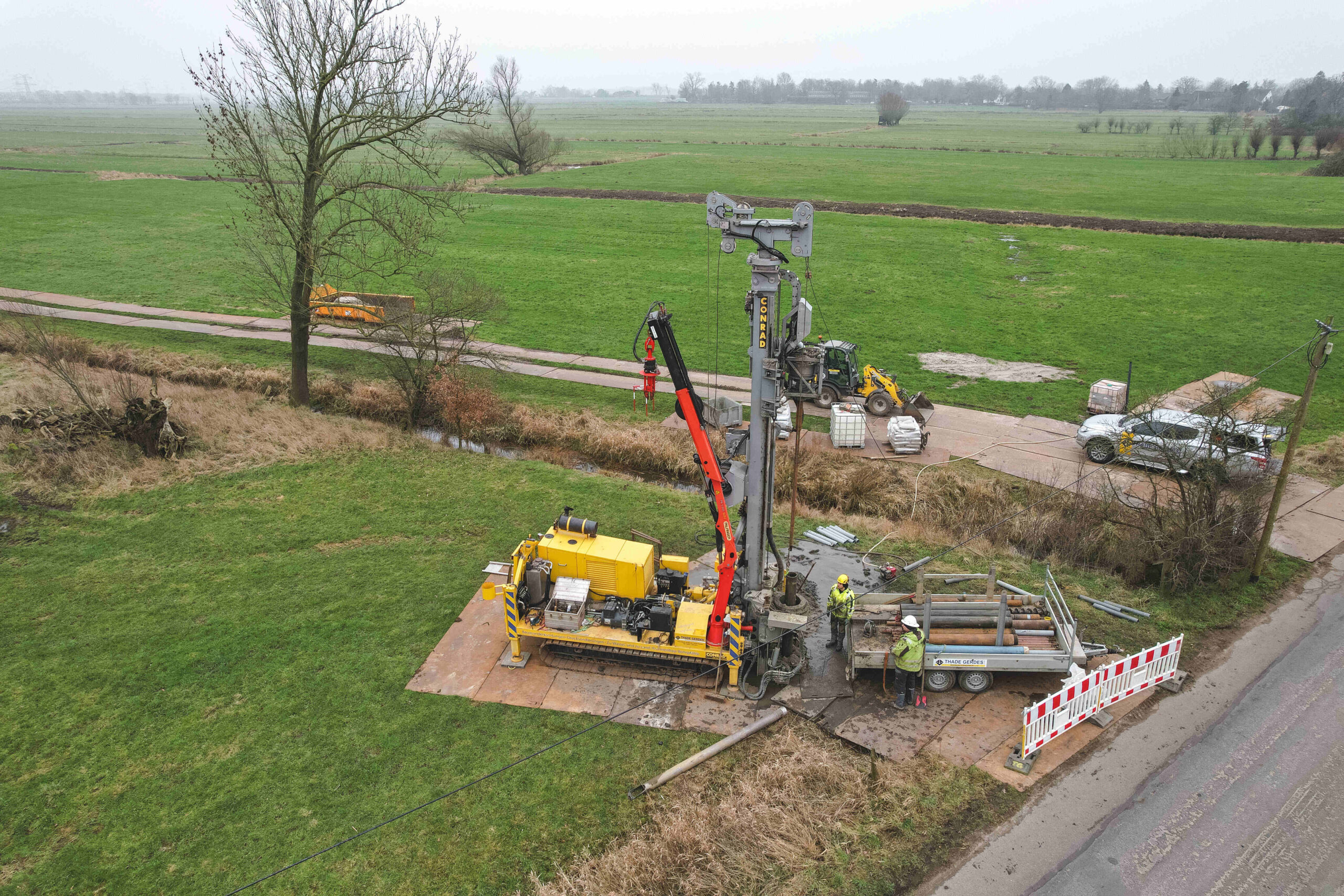 Bohrgerät und Einsatzfahrzeuge bei der Baugrunderkundung auf einer Baustelle